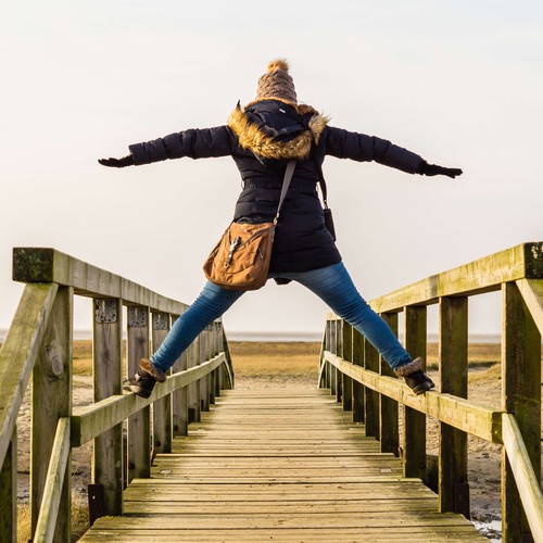 Das Bild zeigt eine Person, die breitbeinig auf dem Geländer eine Brücke steht. © AdobeStock / Animaflora PicsStock